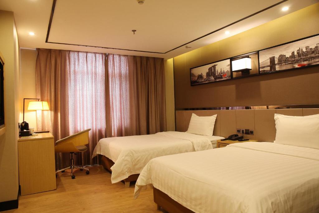 Habitación de hotel con 2 camas y ventana en 7Days Dongguan Tangxiayin Square Walmart, en Dongguan