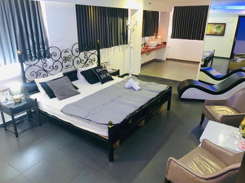 a bedroom with a large bed and two chairs at Spat Rooms VIP in Petaẖ Tiqwa