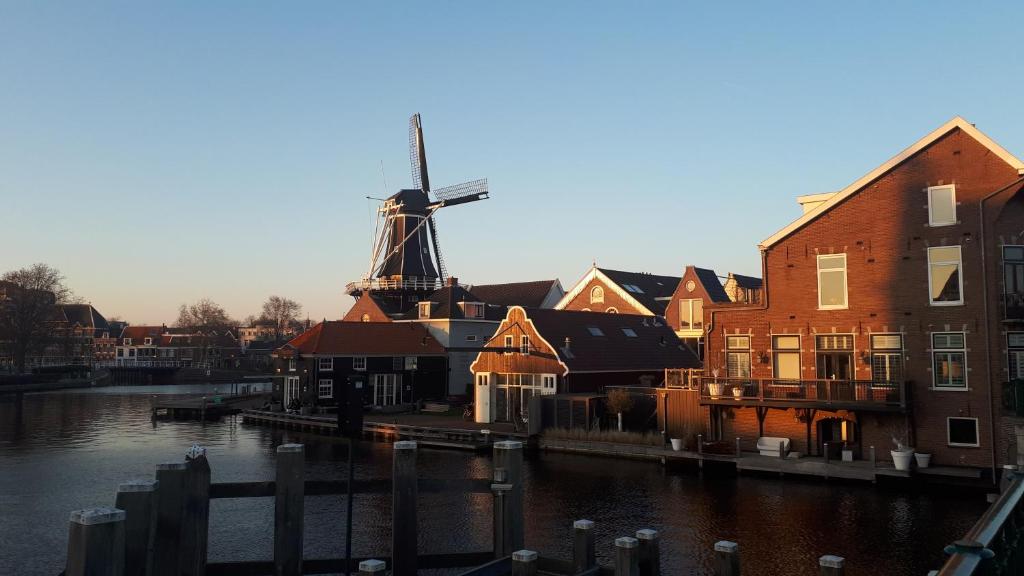 a windmill in the middle of a city with buildings at Feels Like Home in Haarlem