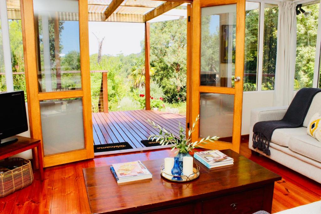 a living room with a couch and a table at Nagoondie Studio in Healesville