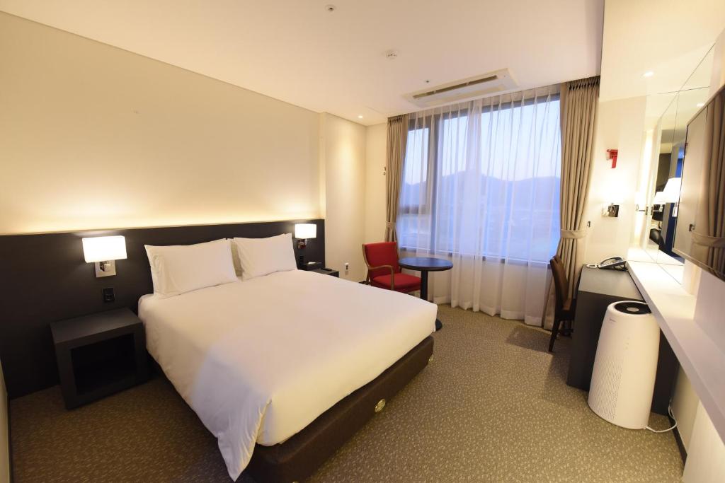 Postel nebo postele na pokoji v ubytování Geoje Artnouveau Suite Hotel
