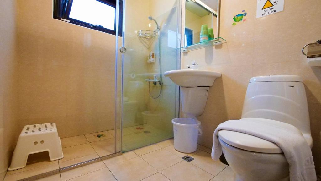 a bathroom with a glass shower and a toilet at Sabai B&amp;B 澎湖船家寶民宿 in Huxi