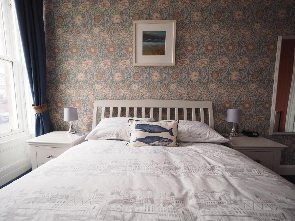 特維德上游的貝里克的住宿－Cowrie Guest House，一间卧室配有一张床和两张带台灯的桌子。