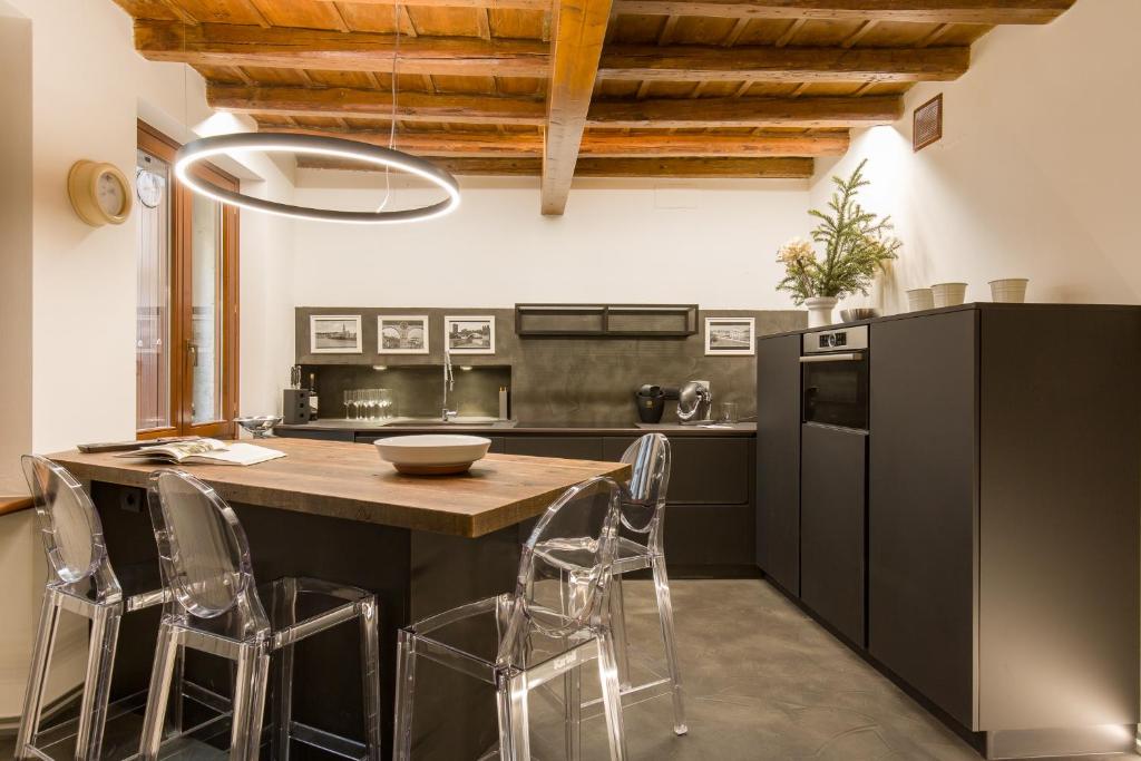 uma cozinha com uma mesa de madeira e cadeiras em Casa Savio em Verona