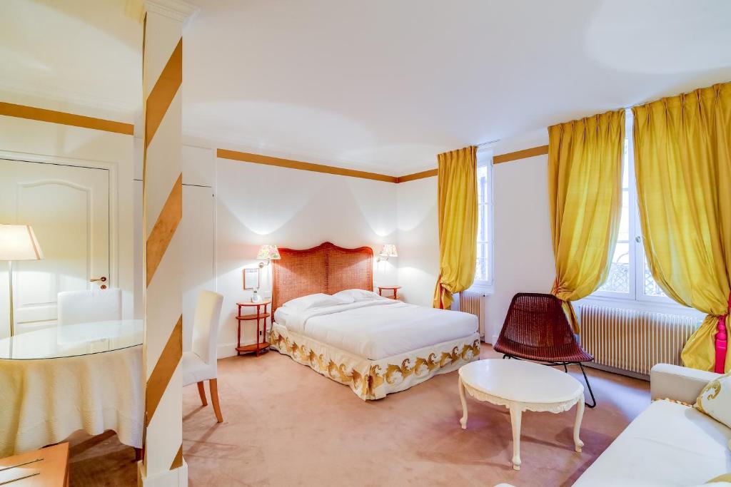 a hotel room with a bed and a table and chairs at Villa Escudier Appart-hôtel in Boulogne-Billancourt