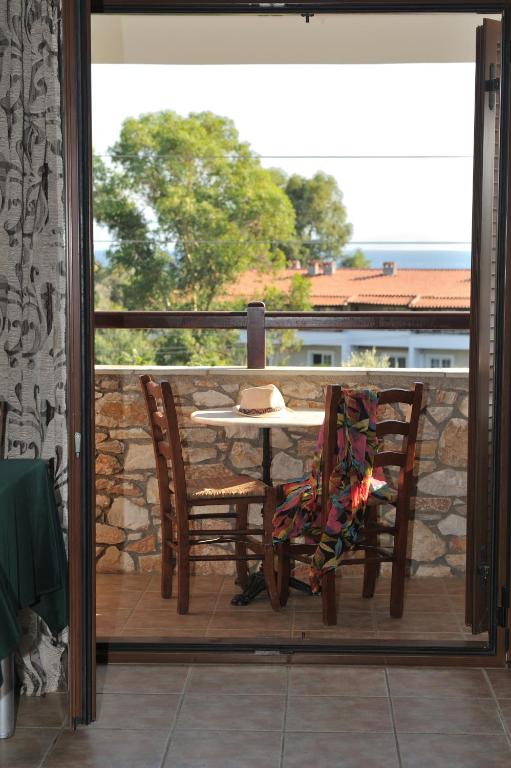 a patio with a table and chairs on a balcony at Villa Maraki in Agia Paraskevi