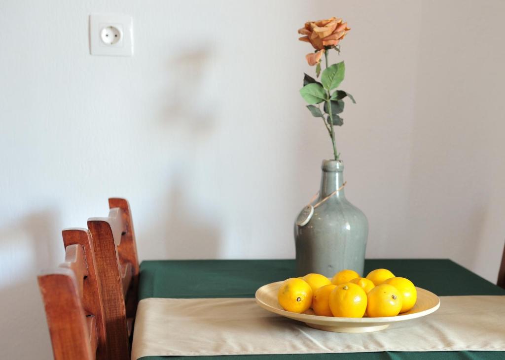 a bowl of lemons on a table with a vase at Villa Maraki in Agia Paraskevi