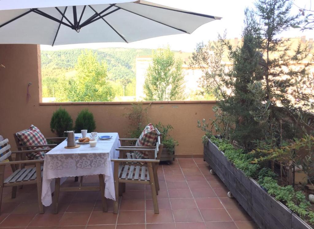 a table and chairs with an umbrella on a patio at BIOK Ainsa Ordesa-Monte Perdido' in Aínsa