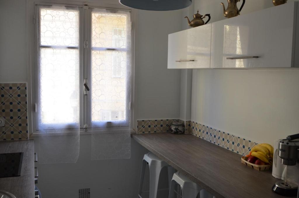a kitchen with white cabinets and a wooden counter top at 4 Rue Guigonis in Nice
