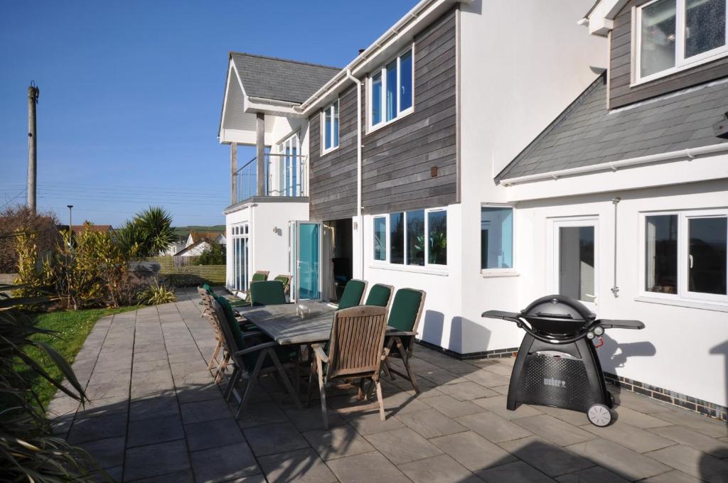 a patio with a table and chairs and a house at Seascape in Croyde