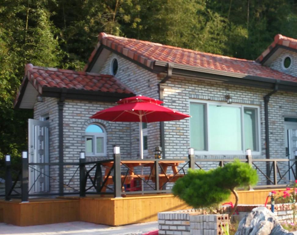 a small house with a table and an umbrella at Chungaram in Damyang