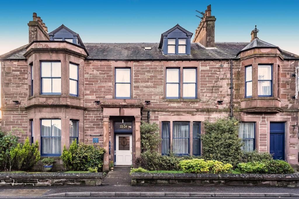 una vecchia casa di mattoni con una porta bianca di Tigh Na Leigh ad Alyth