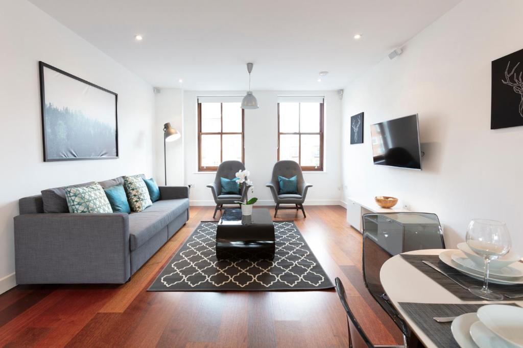a living room with a couch and a table at Hampden Apartments - The Charles in Windsor