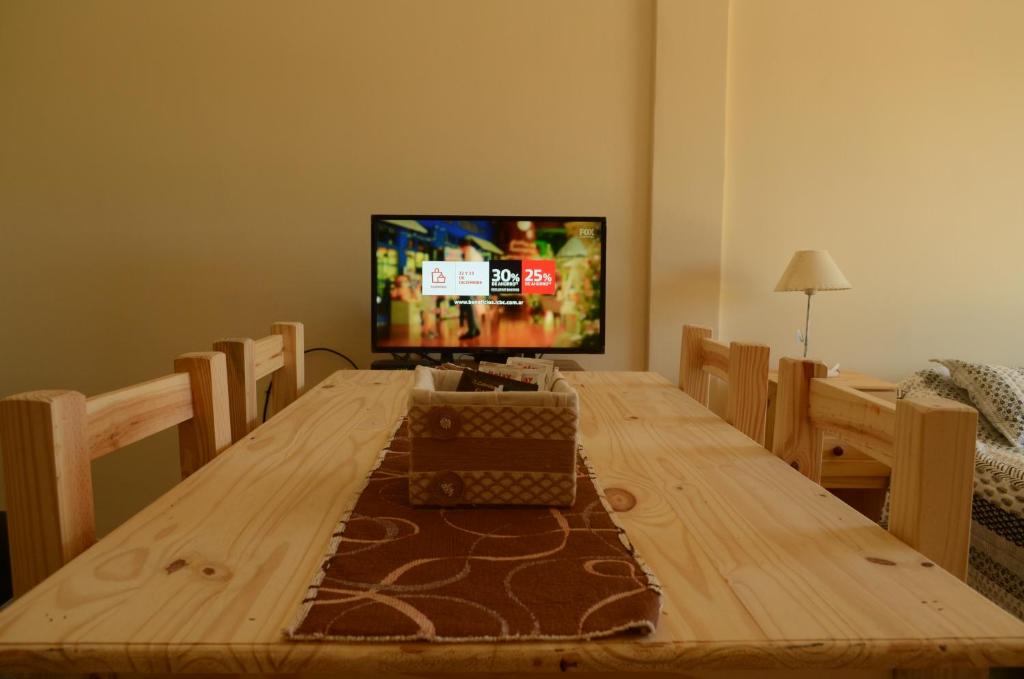 einen Holztisch mit einem TV im Wohnzimmer in der Unterkunft City Apartments Formosa in Formosa