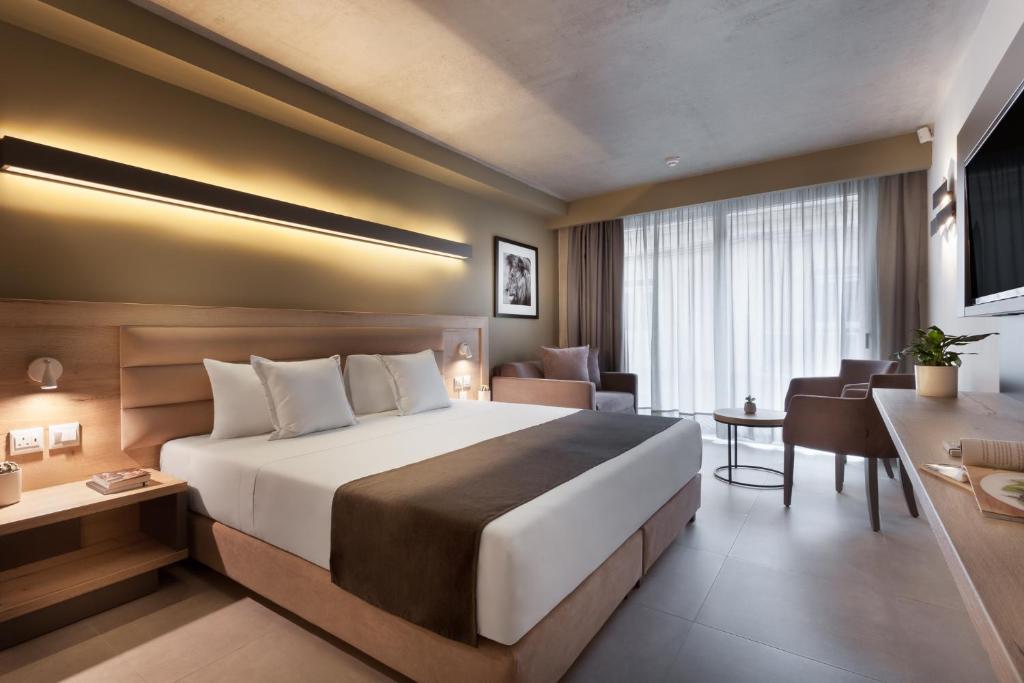 a hotel room with a large bed and a desk at Azur Hotel by ST Hotels in Il-Gżira