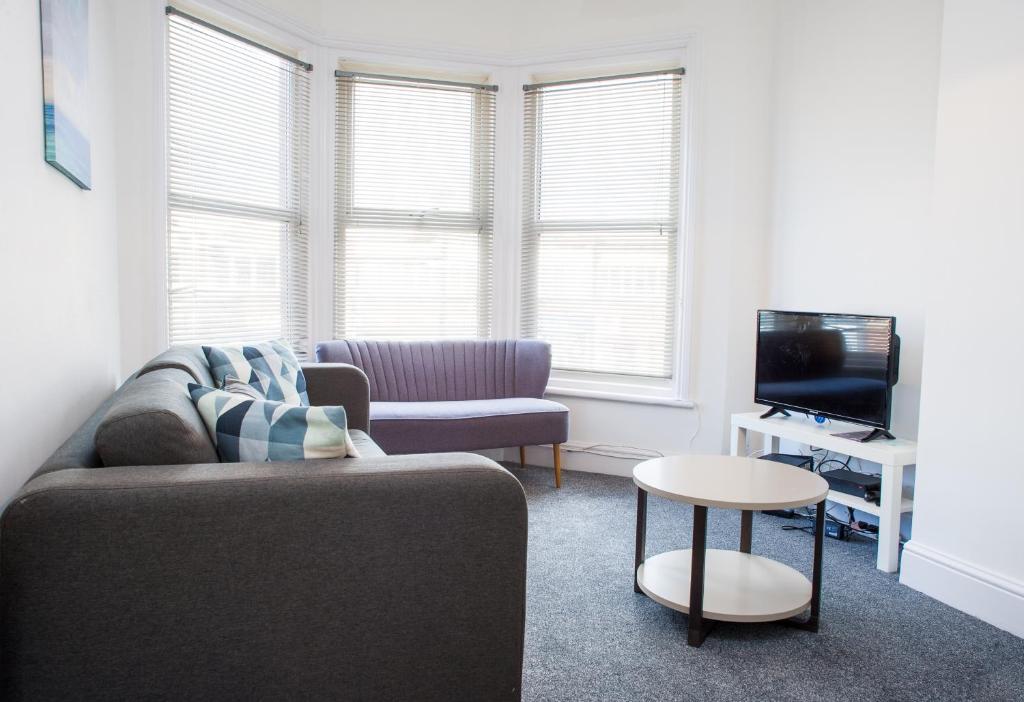 a living room with a couch and a tv at MyCityHaven - Stylish & Flexible Shirehampton Apartment in Bristol