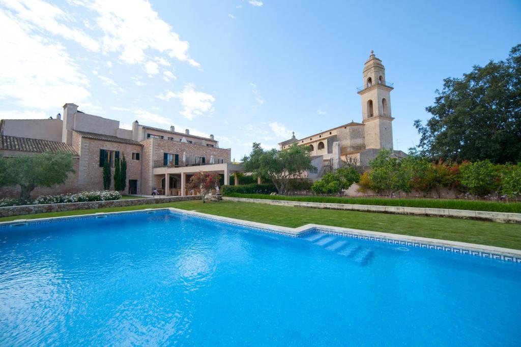une grande piscine bleue en face d'un bâtiment dans l'établissement Hotel Ca'n Bonico, à Ses Salines