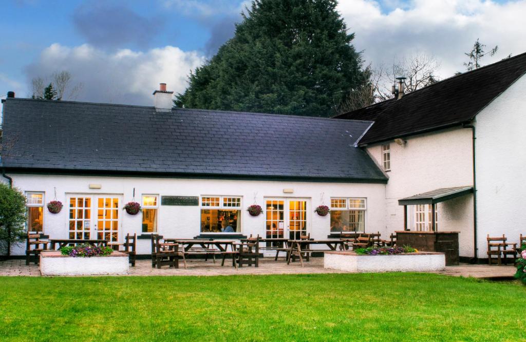 a white building with a picnic table in front of it at Brown Trout Golf & Country Inn in Aghadowey