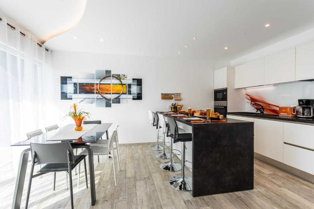 a kitchen with white cabinets and a black table and chairs at Villa Valis in Baška