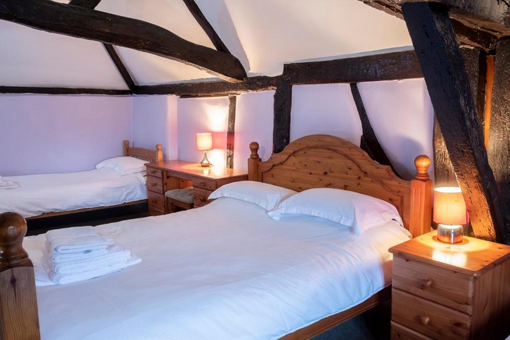 duas camas num quarto com duas lâmpadas nas mesas em The Crown Hotel em Alton