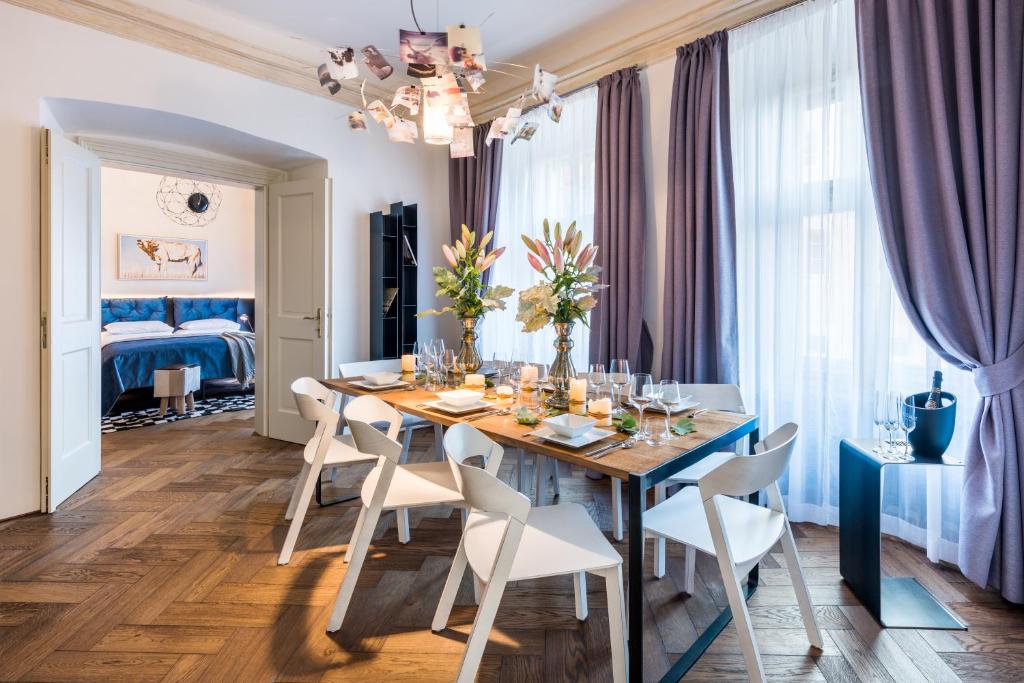 a dining room with a blue table and white chairs at MOOo by the Castle in Prague