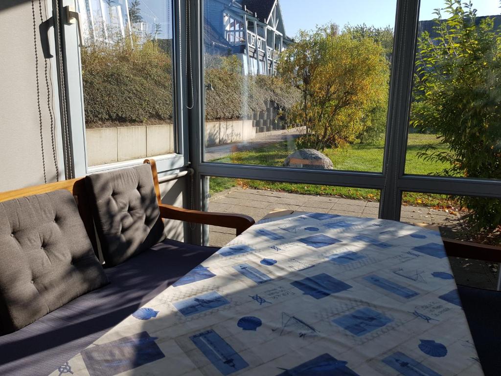 ein Schlafzimmer mit einem Bett und einem Tisch und einem Fenster in der Unterkunft Ferienwohnung 4 im Haus am See mit Wintergarten und Terrasse in Seedorf