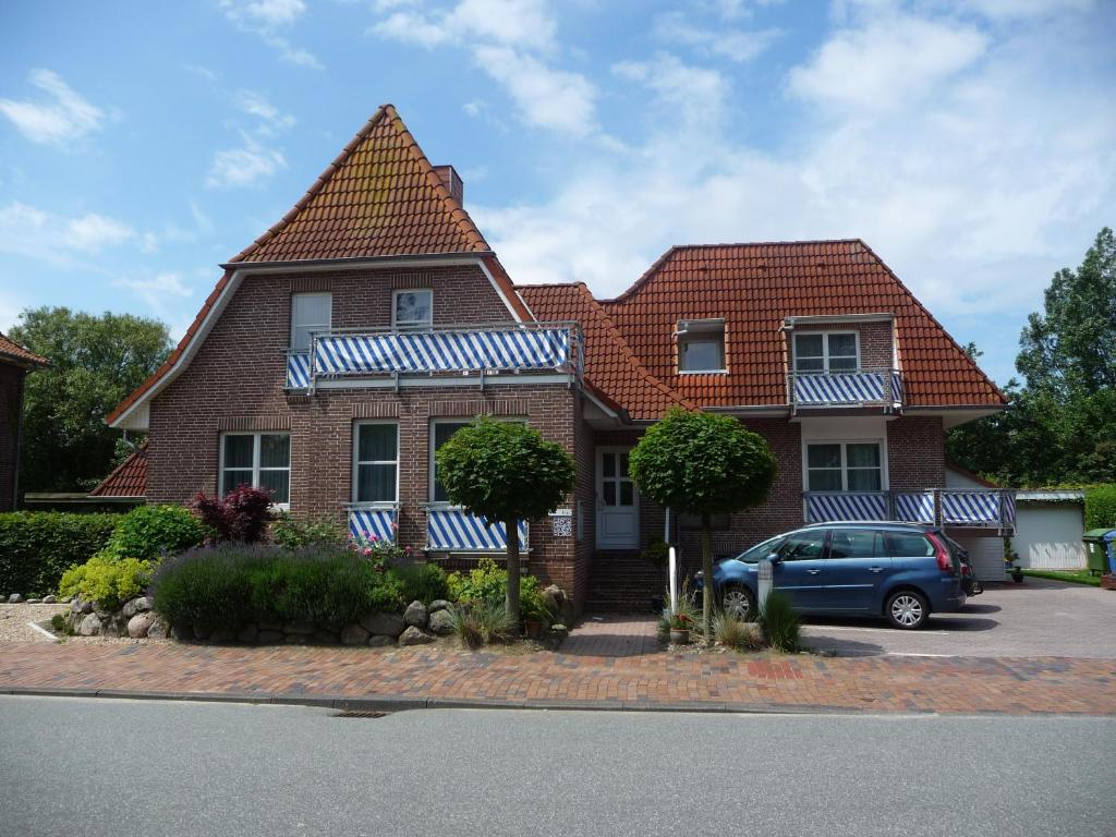 a house with a car parked in front of it at Strandhaus am Kurpark in Cuxhaven