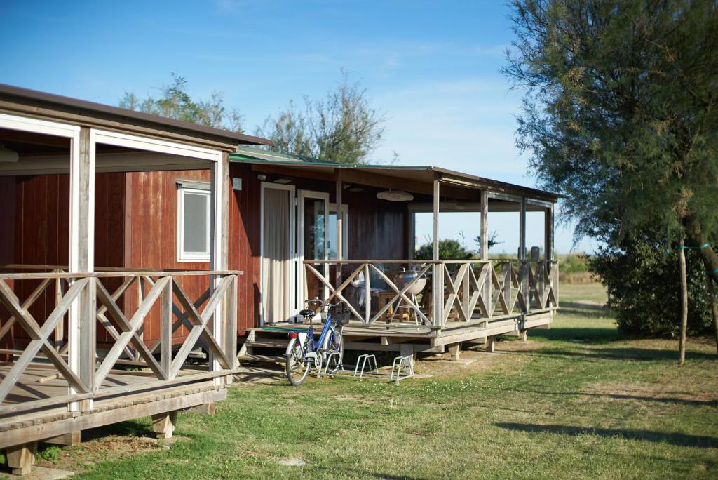 a cabin with a bike parked in front of it at Camping Village Capalonga in Bibione