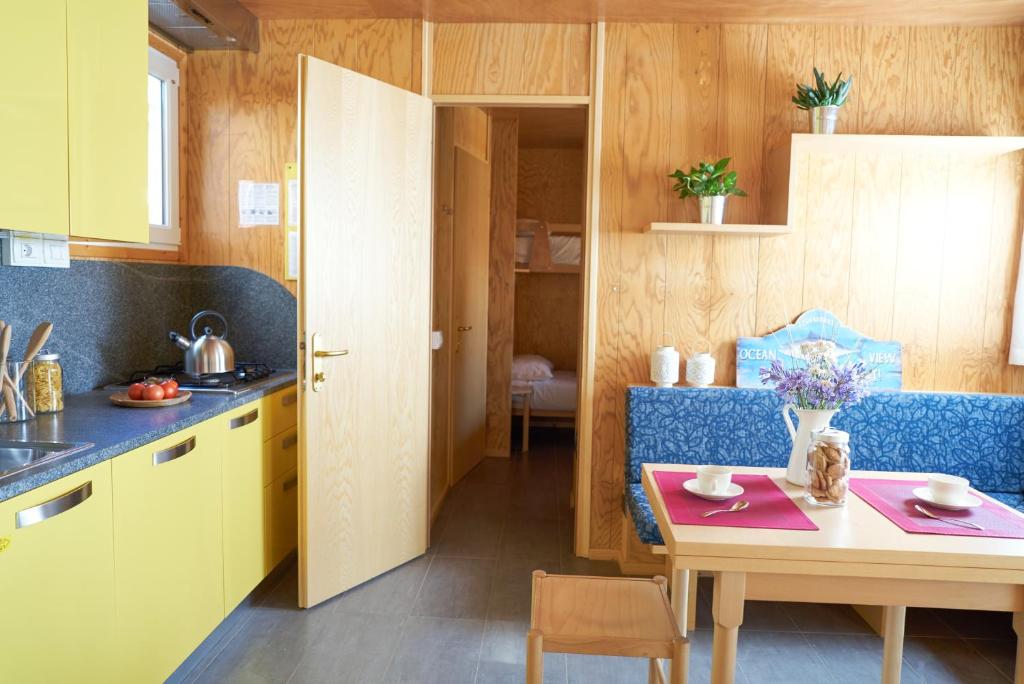 a kitchen with a table and a dining room at Camping Village Capalonga in Bibione
