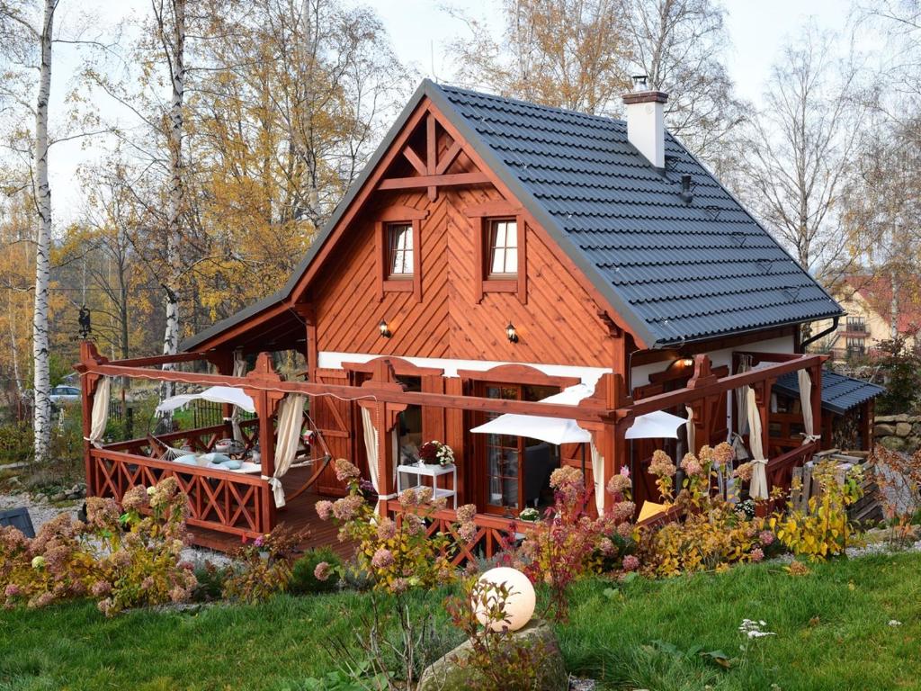 ein großes Holzhaus mit schwarzem Dach in der Unterkunft Domek w Karkonoszach in Preseka