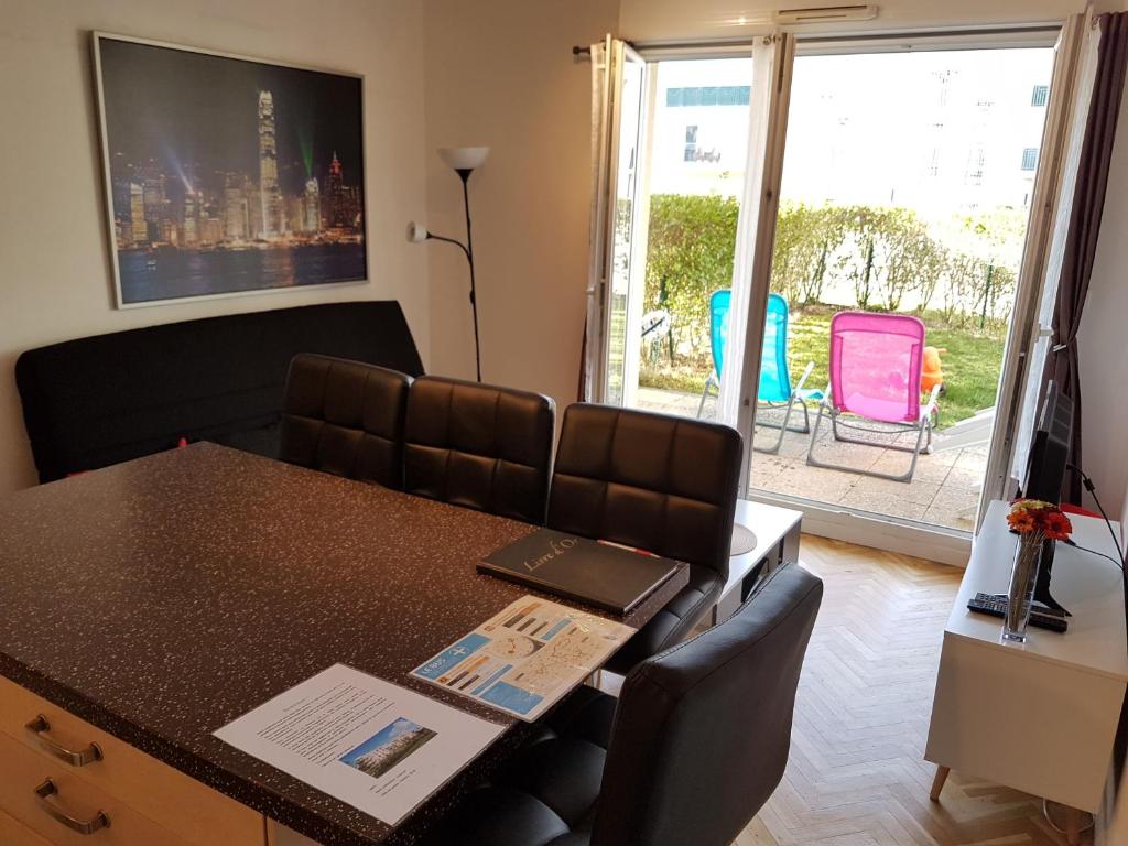 a conference room with a table and chairs and a window at Appartement avec rez de jardin à Disneyland in Montévrain