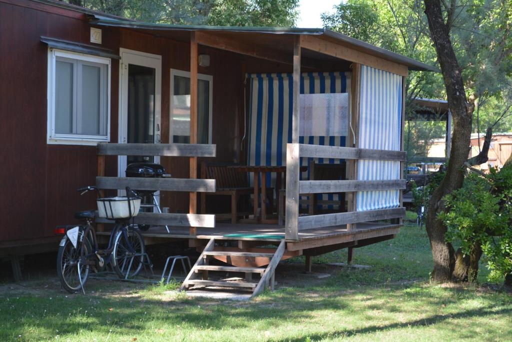 a house with a bike parked in front of it at Camping Village Capalonga in Bibione