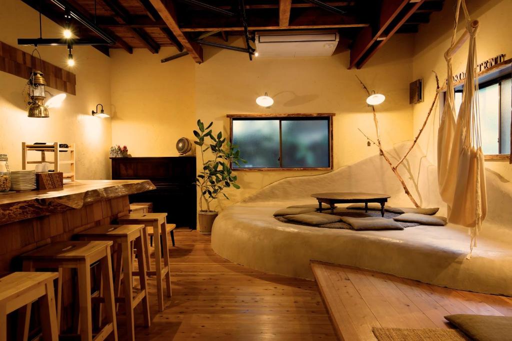 Habitación con cama, mesa y sillas. en Onsen Guesthouse HAKONE TENT, en Hakone