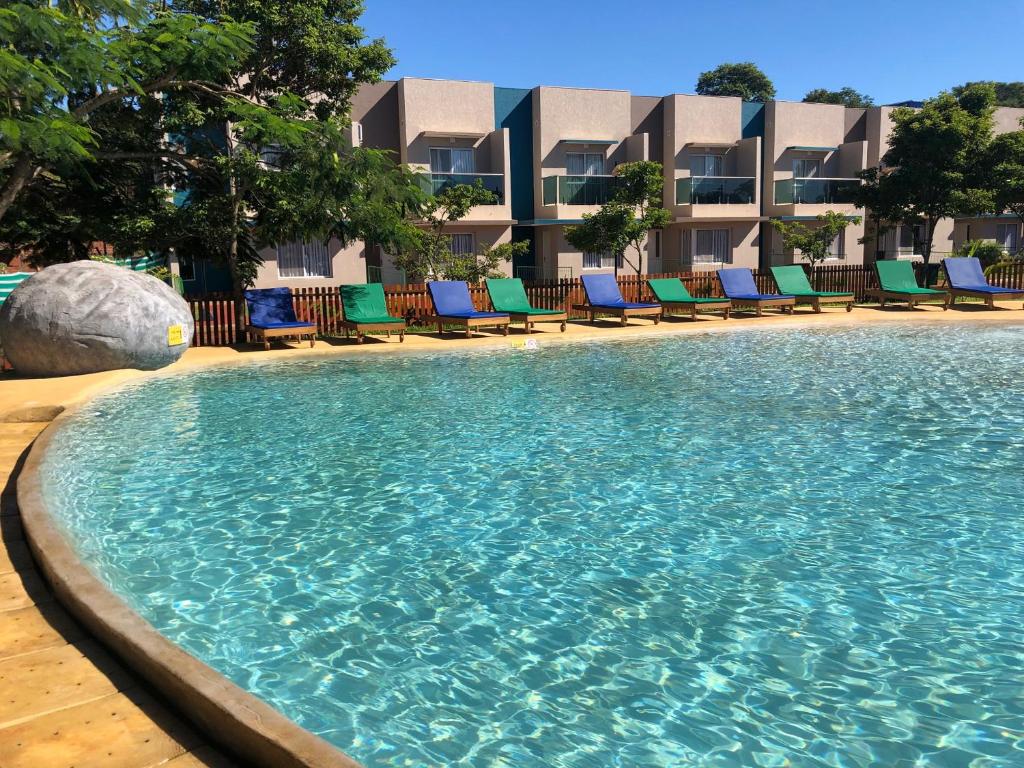 uma piscina com cadeiras e um hotel ao fundo em Z Hotel Boutique em Puerto Iguazú