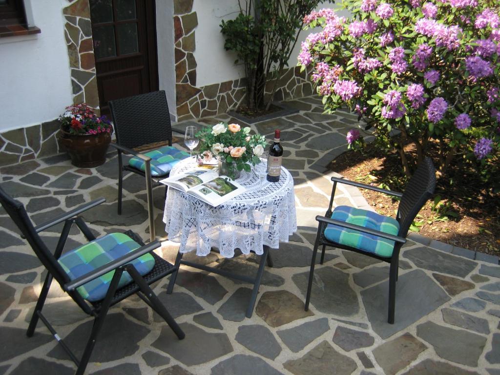 a table and chairs on a patio with flowers at Ferienwohnung am Nationalpark in Reifferscheid
