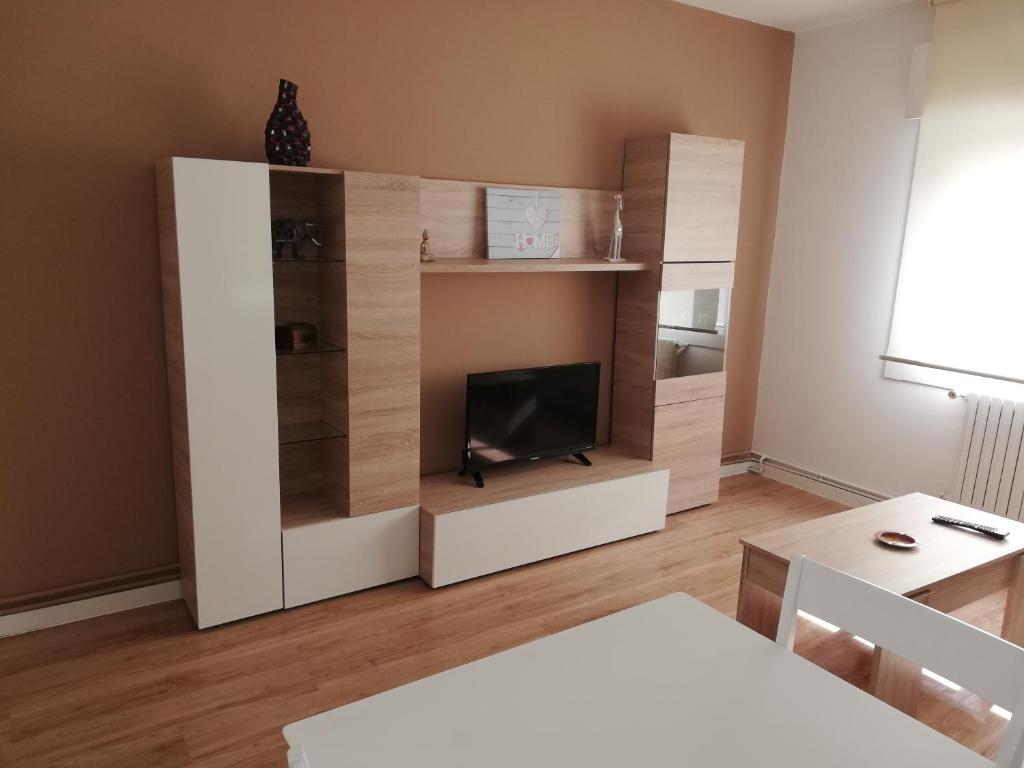 a living room with a tv in a white cabinet at Apartamento Calzada II in Santiago de Compostela