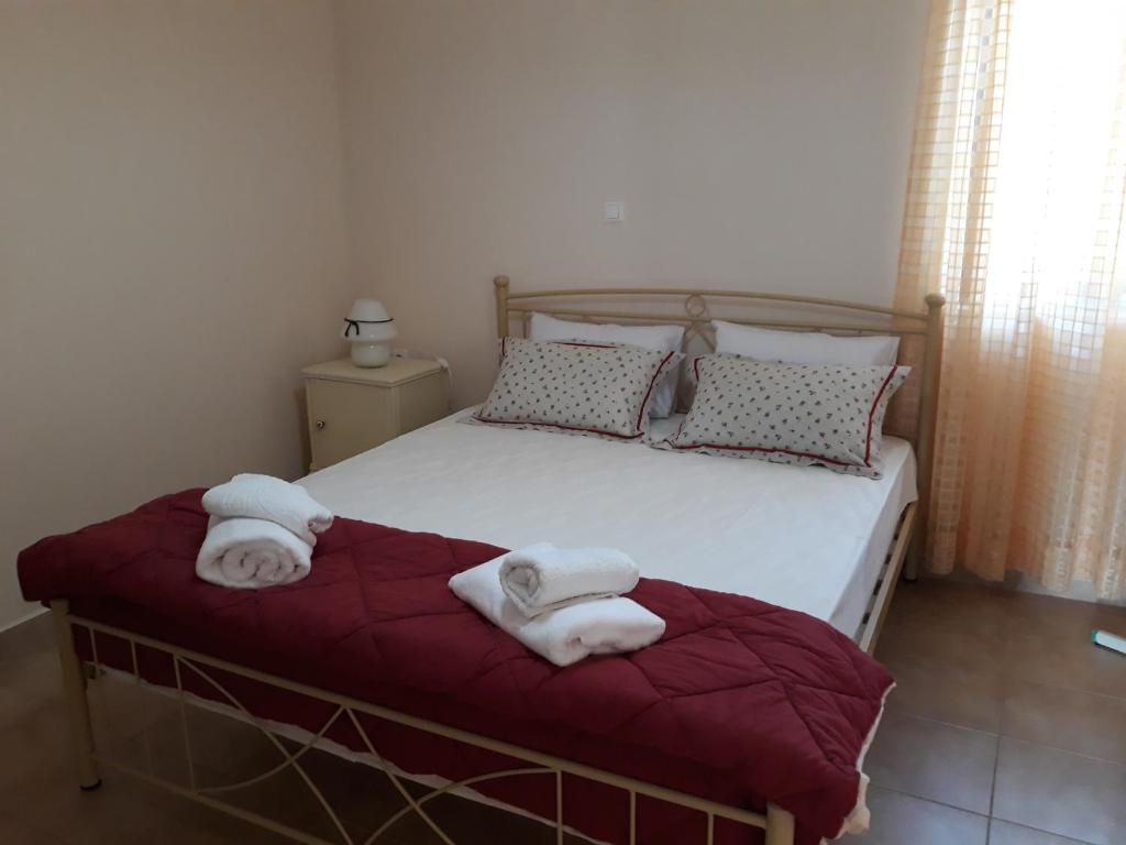 a bedroom with a bed with towels on it at MARIA GUESTHOUSE KINI in Kinion