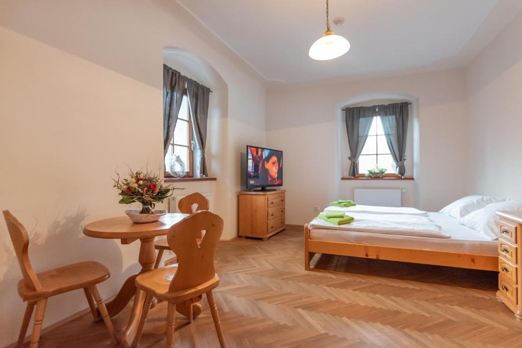 a bedroom with a bed and a table and chairs at Restaurace a penzion Stará pošta in Bečov nad Teplou