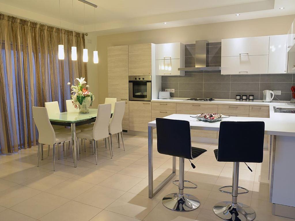 a kitchen with a table and chairs in a kitchen at Tas-Sellum Residence in Mellieħa