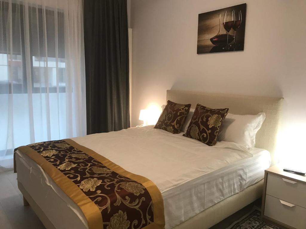 um quarto com uma cama grande e uma janela em 21 Residence Apartments em Bucareste