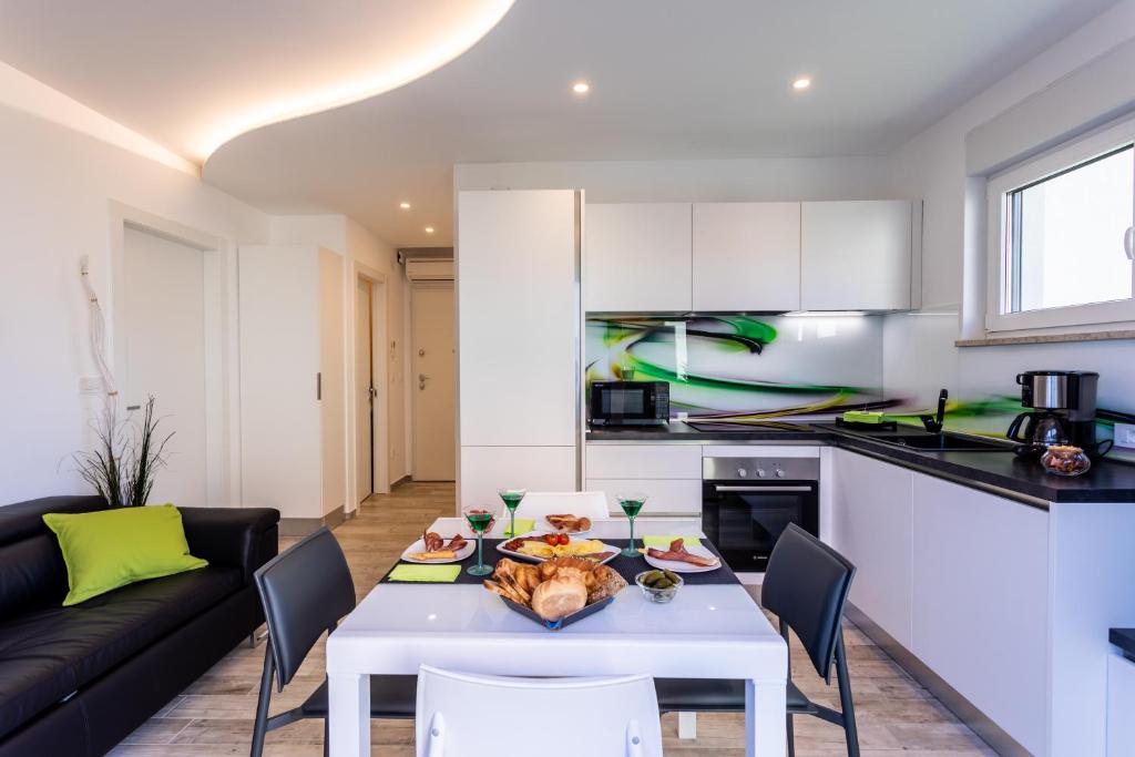 a kitchen and living room with a white table and chairs at Villa Valis in Baška