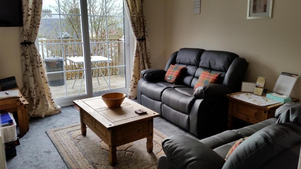 a living room with a couch and a table at Apartment 4 Pheonix Flats in Portree