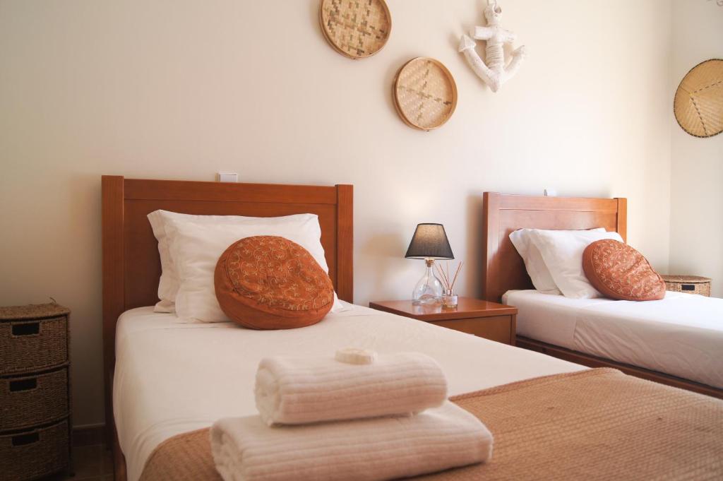 
a hotel room with a bed, desk, lamp, and mirror at Aloha Burgau Guesthouse in Burgau

