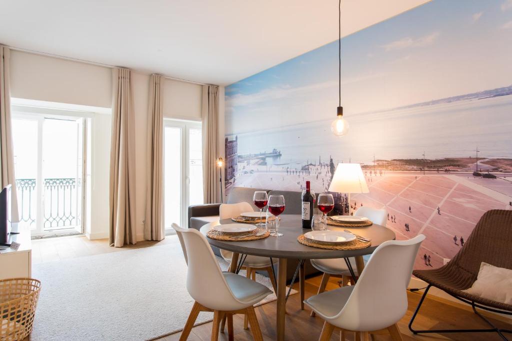 uma sala de jantar com uma mesa e cadeiras com copos de vinho em ALTIDO Elegant Liberdade Apartments em Lisboa