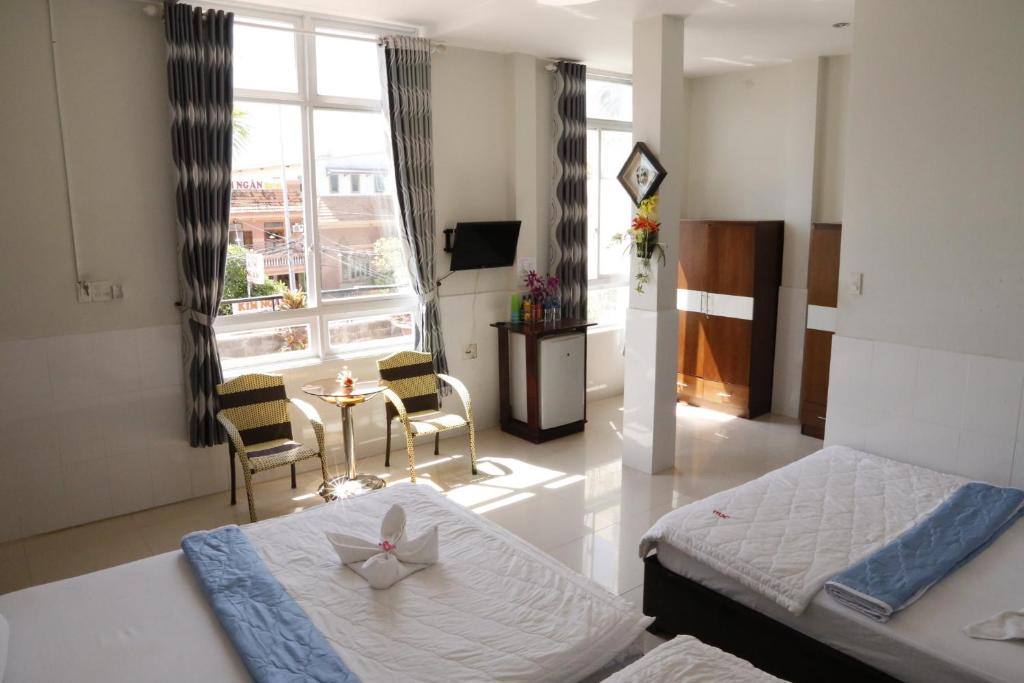1 dormitorio con 1 cama, mesa y sillas en Minh Hung Hotel, en Mui Ne