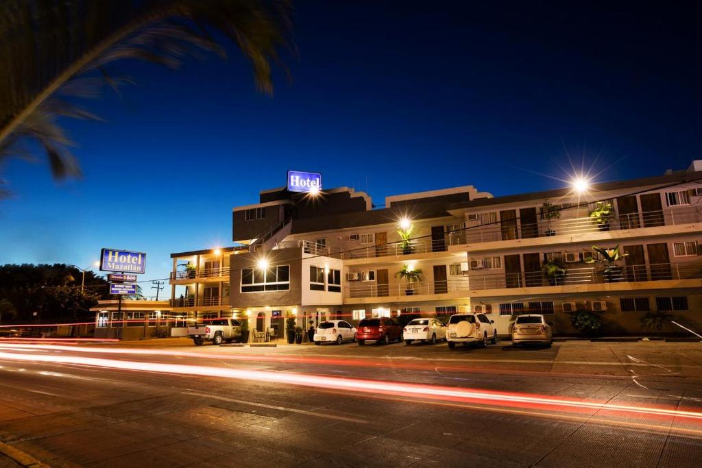 馬薩特蘭的住宿－馬薩特蘭酒店，一座有汽车在晚上停在停车场的建筑