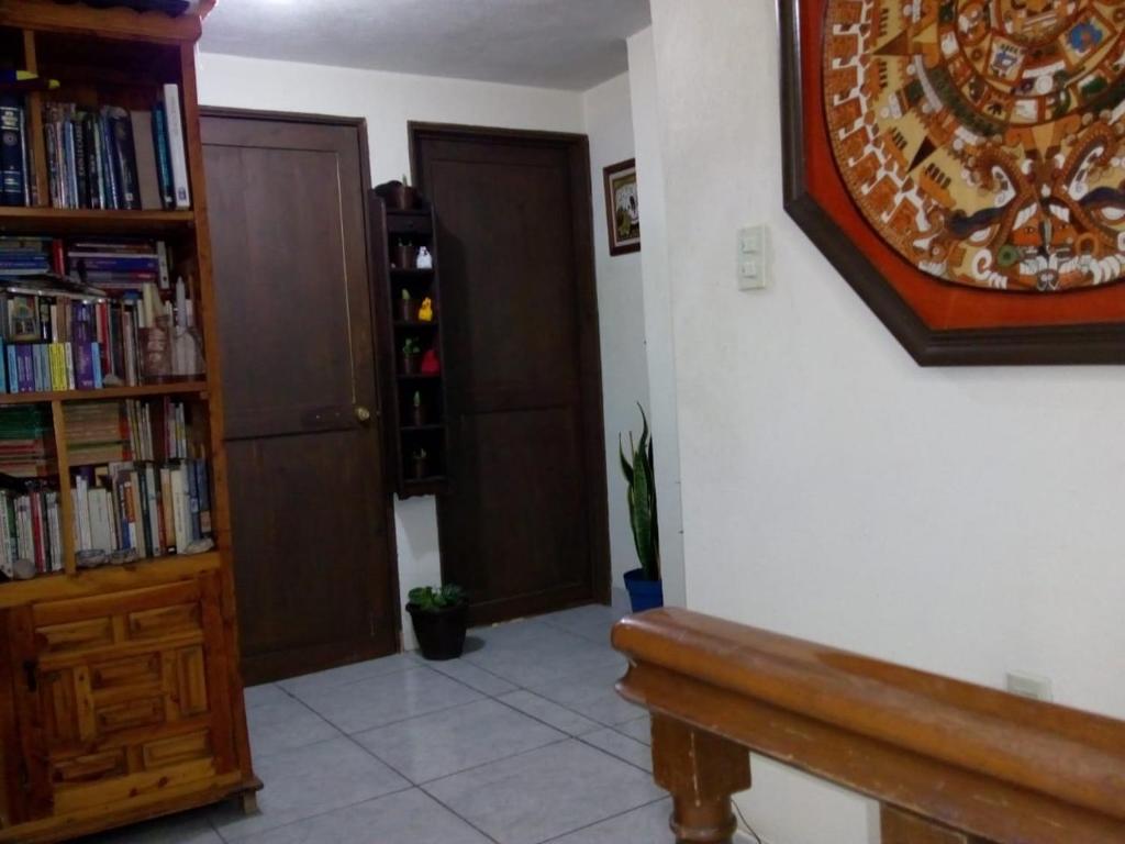 a room with a book shelf and a wooden bench at Recámara rústica in Mexico City