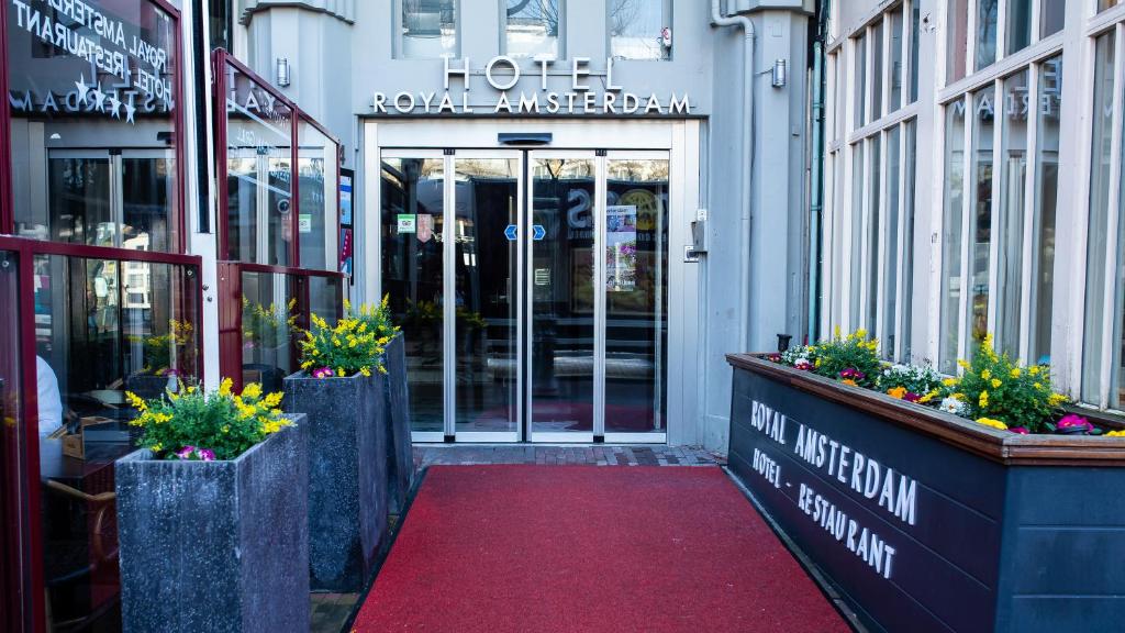 a front door of a hotel with flowers on a red carpet at Royal Amsterdam Hotel in Amsterdam
