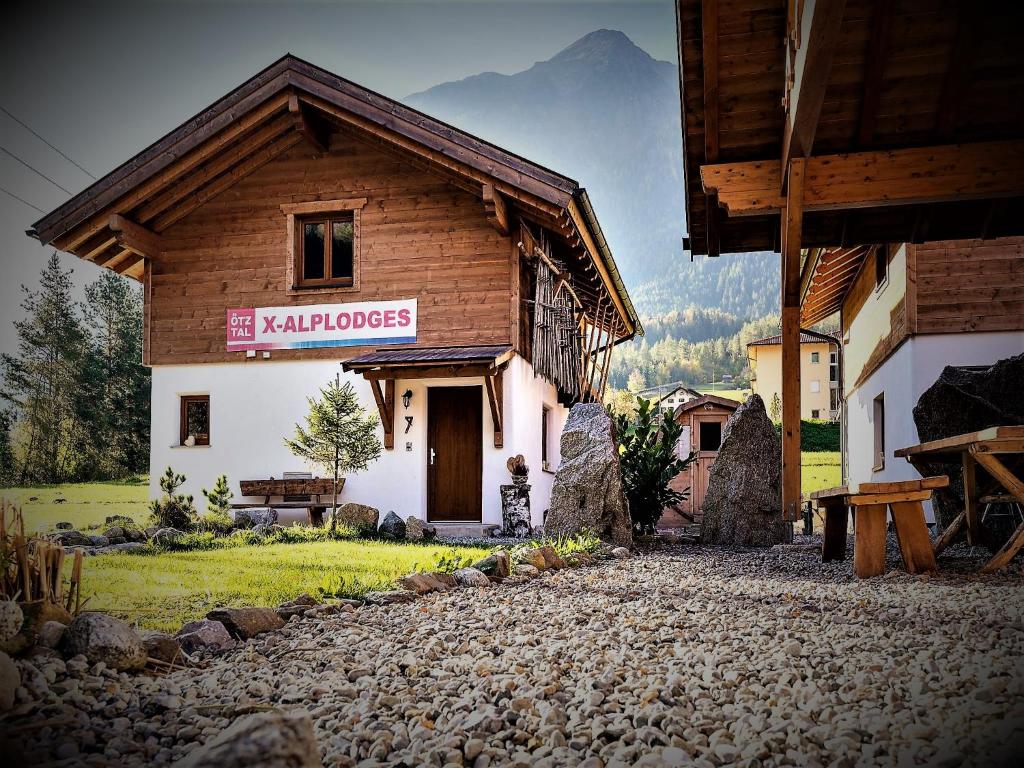 a building with a sign that reads the karamboos at X-Alp Lodges in Sautens