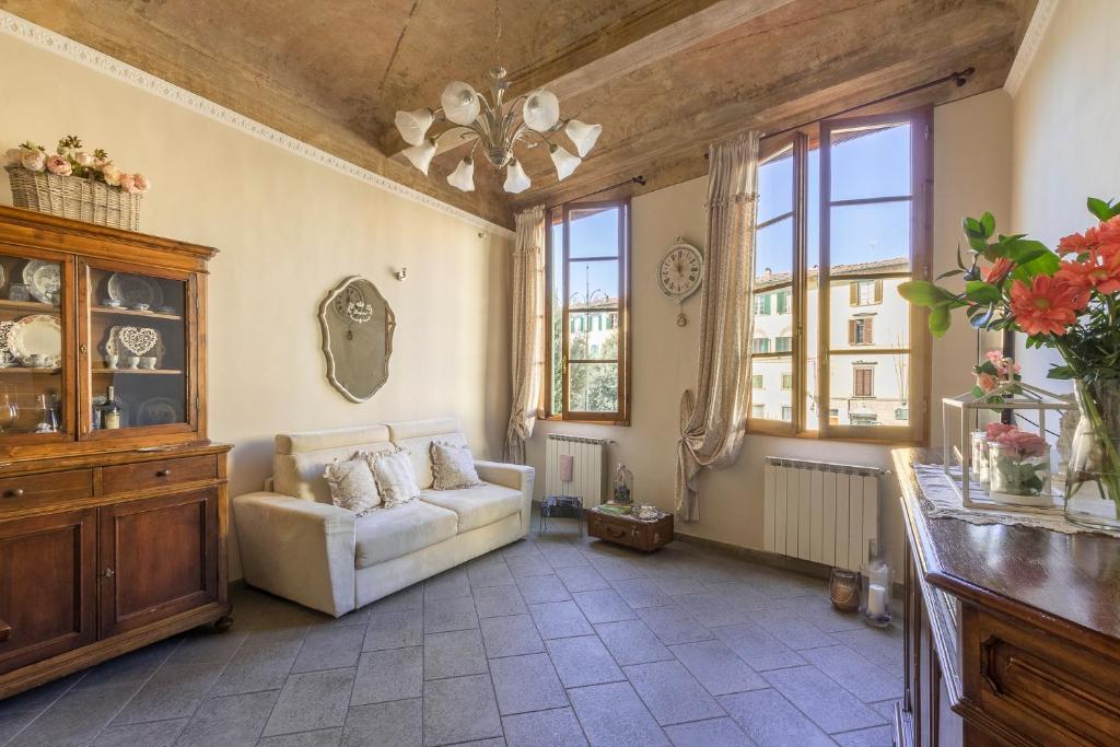 sala de estar con sofá y algunas ventanas en Casa Laura&Duccio en Florence